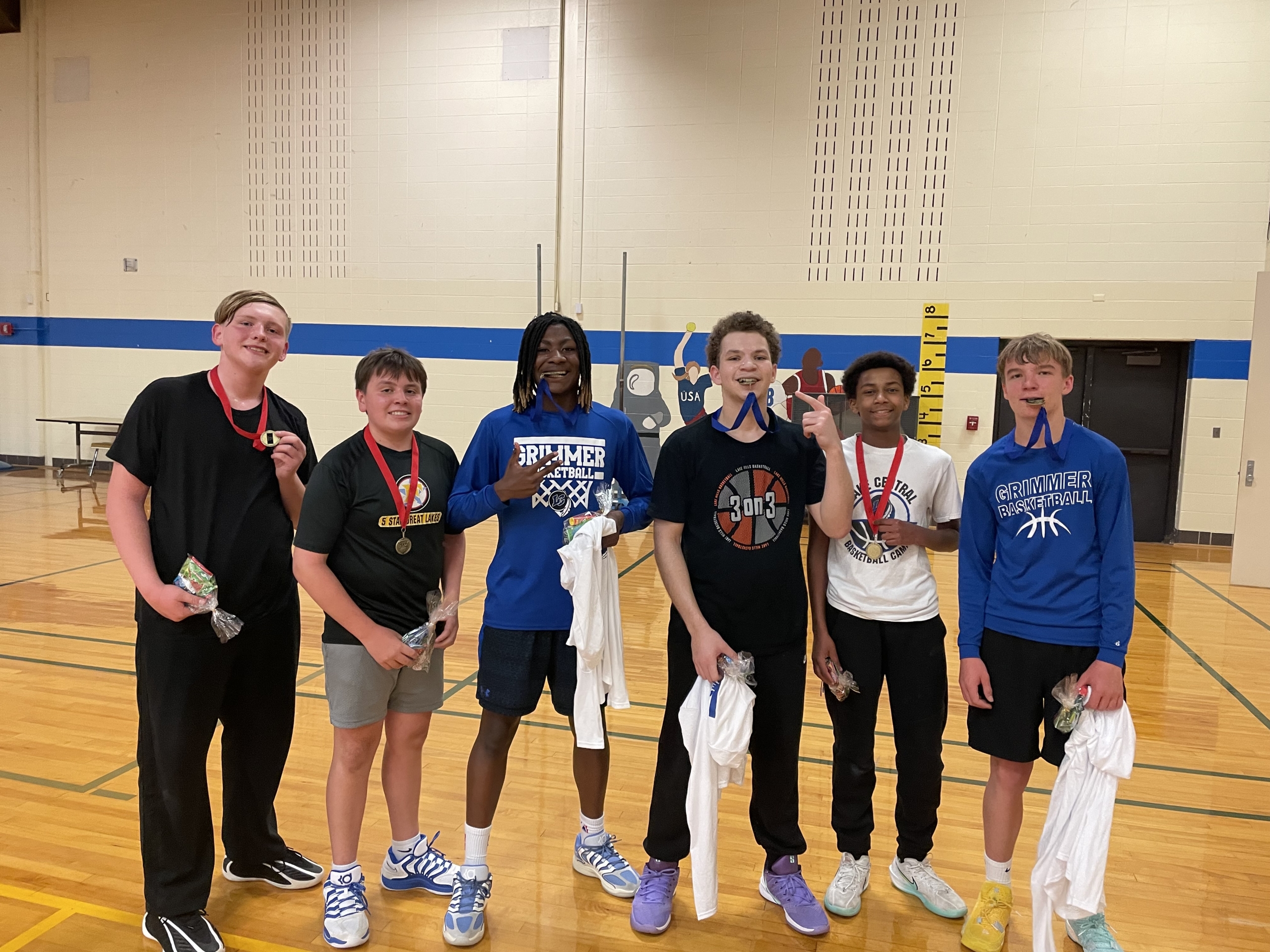 Grimmer boys wearing medals and posing in the gym.