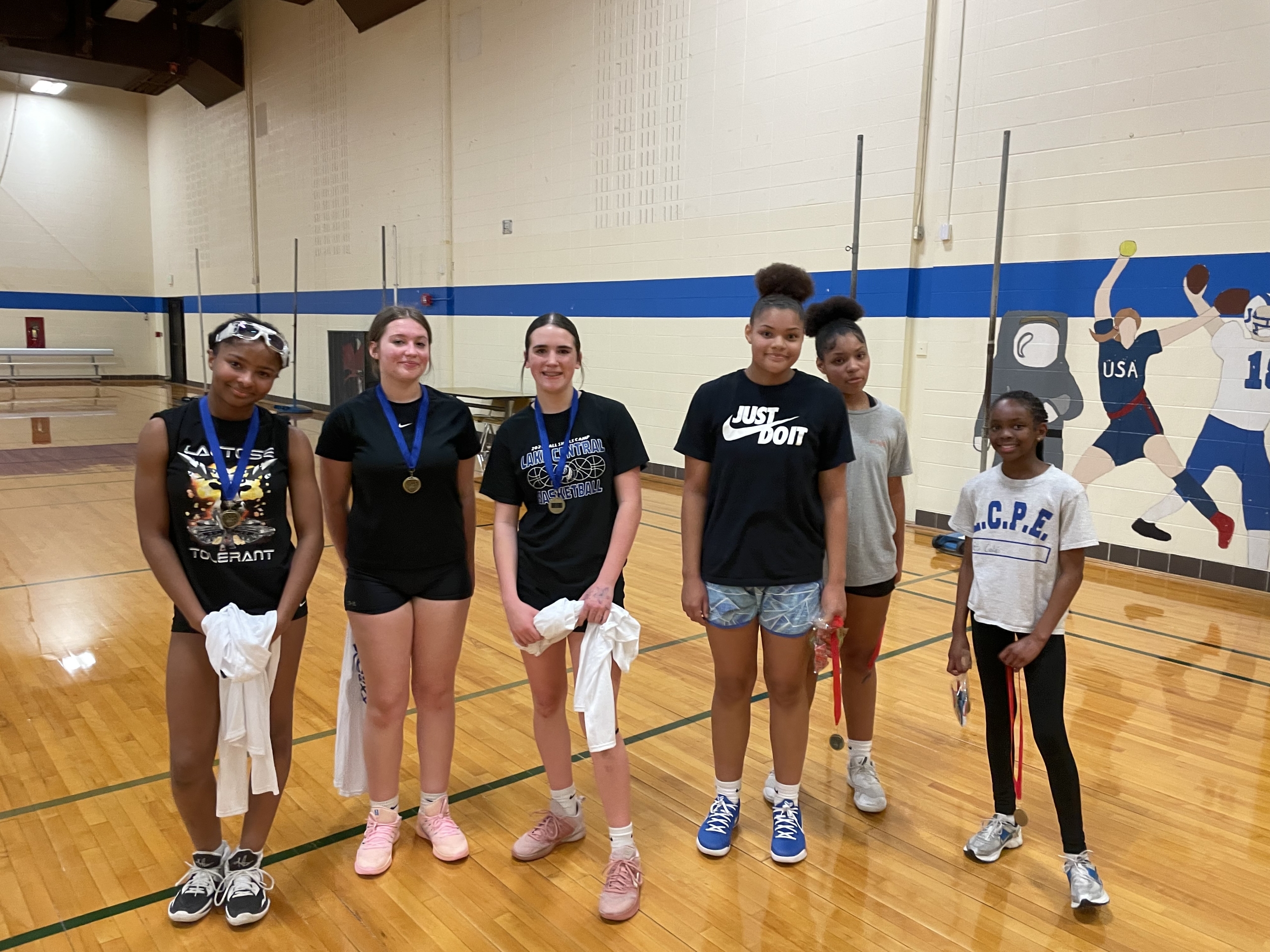 Grimmer girls wearing medals and posing in the gym.