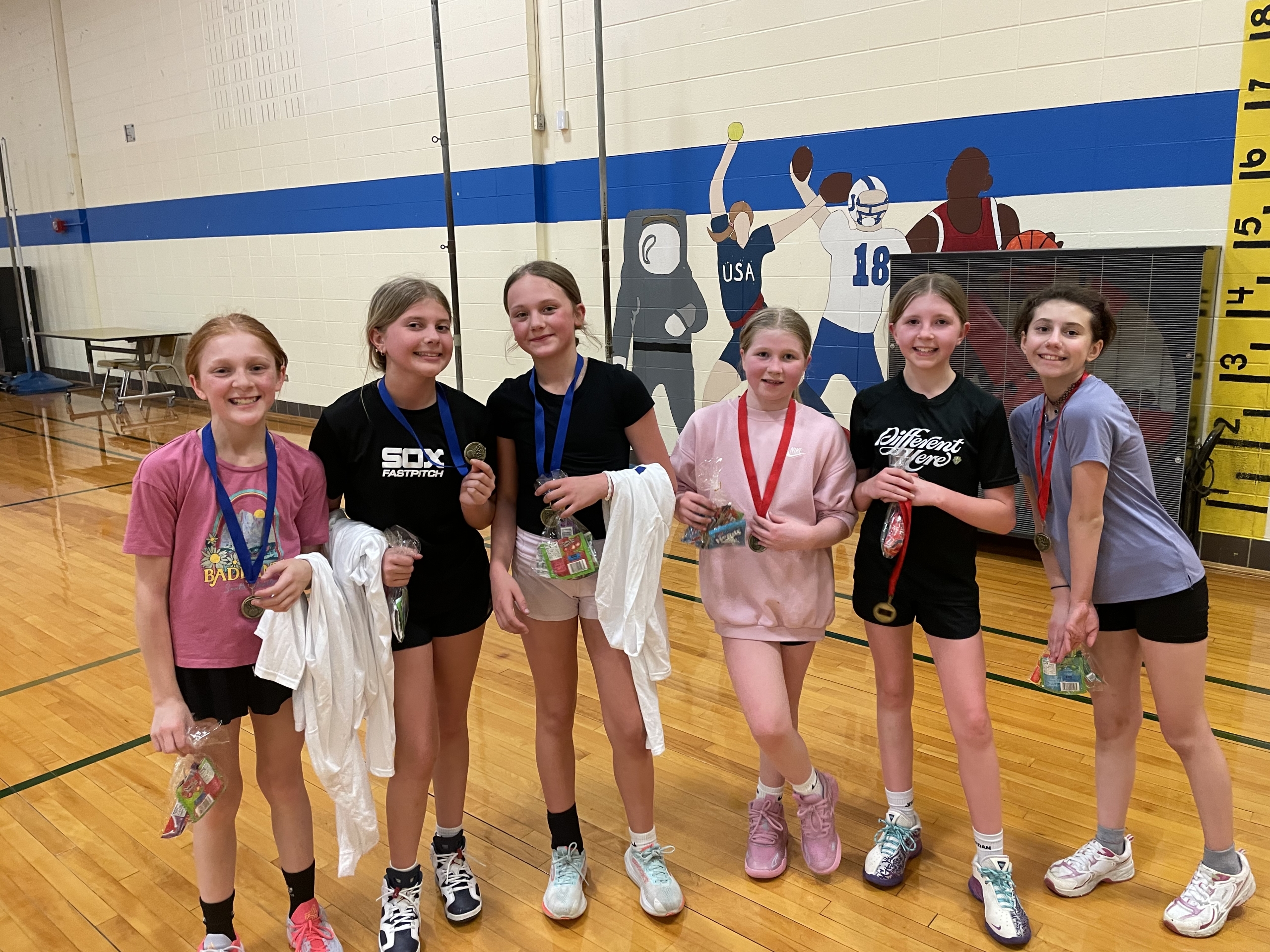 Grimmer girls wearing medals and posing in the gym.